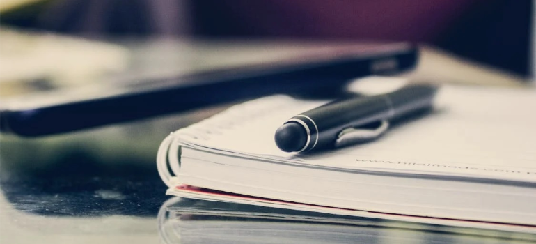 A black twist pen on a notebook.