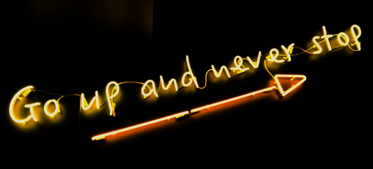 A neon sign that says: "Go up and never stop".