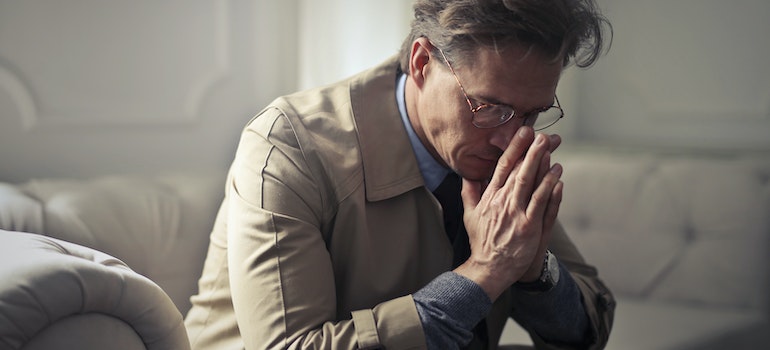 a worried man thinking about the link between addiction and poverty in Morgantown, WV