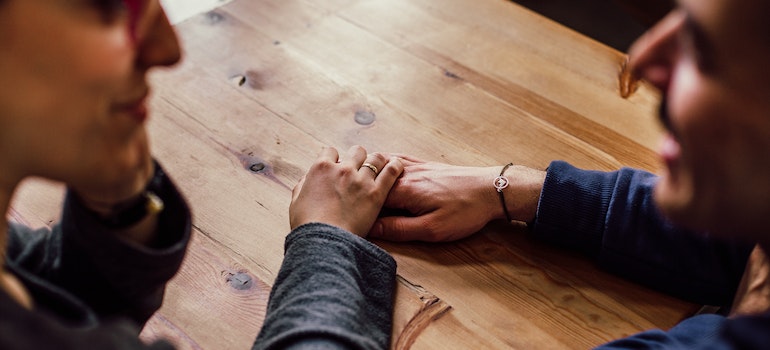 two people holding hands talking about the impact of addiction on the local prison population in Clarksburg, WV
