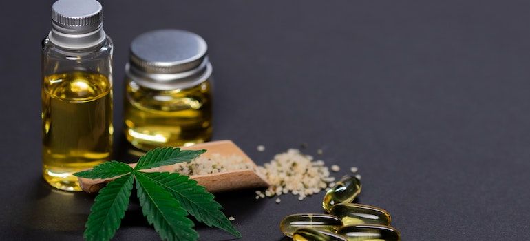 Cannabis leaf and products in little glass bottles and pills