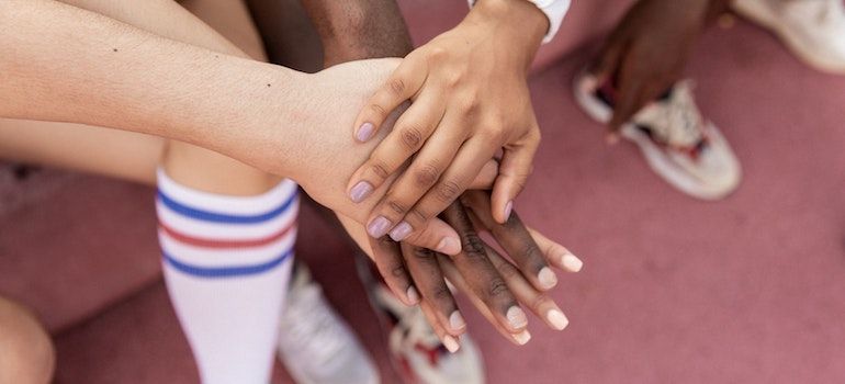 People holding their hands on top of each other to show support