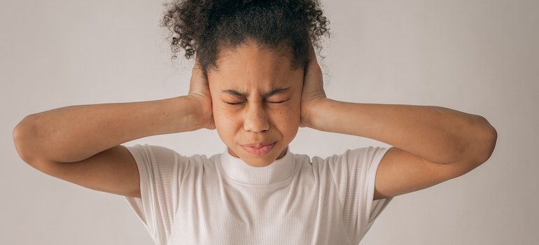 Person holding their ears not to hear anything representing signs of a high-functioning addict