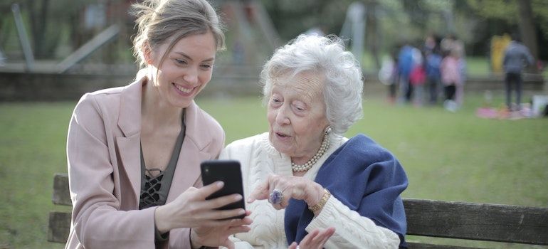 Mother and daughter looking and the phone and smiling while talking about how churches are battling addiction in small towns in WV.