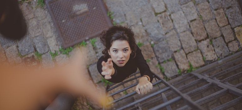 Woman trying to go up a ladder