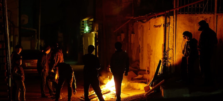 A group of Native Americans in West Virginia gathered around a fire in the street after dark