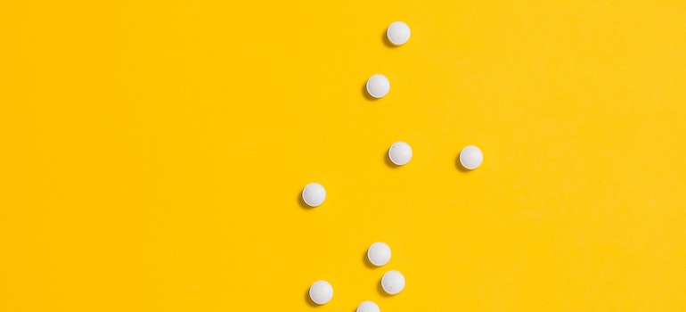 pills on yellow background representing the Impact of Ambien Addiction work or school performance