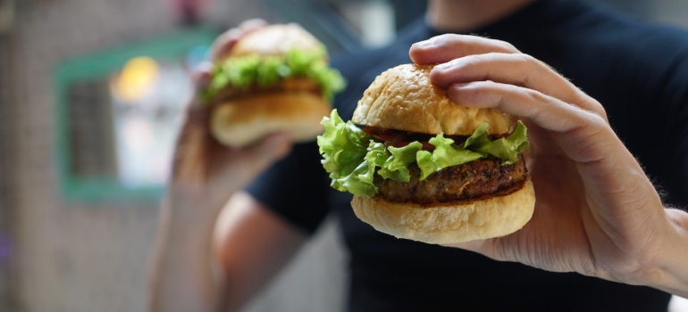 Person holding two hamburgers
