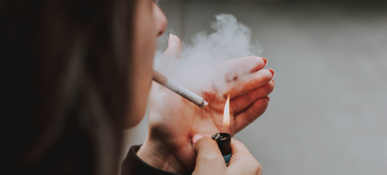 A woman lighting up a cigarette.