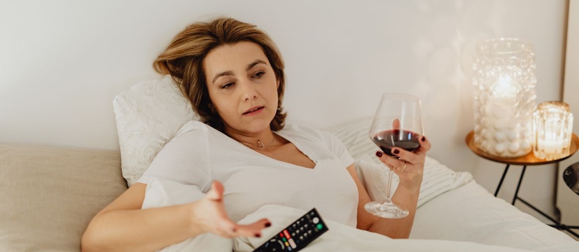 Woman holding a glass of wine and worrying about Wine Mom Culture in Marietta OH.