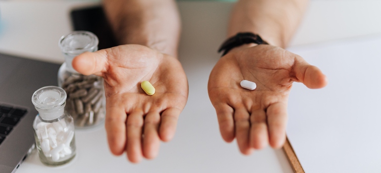 Two palms with a pill in each