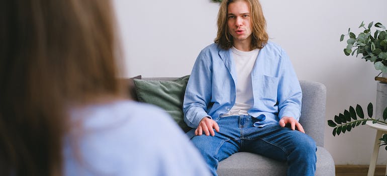 A person talking to a therapist after discussing socio-economic factors affecting drug abuse in Clarksburg