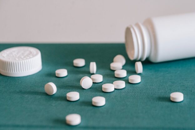Pills spilled out of a white jar representing Nitazenes Abuse in WV