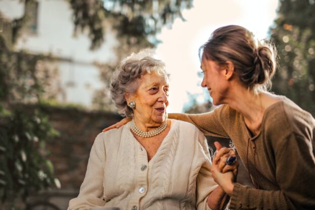 An elderly woman and a young woman hugging