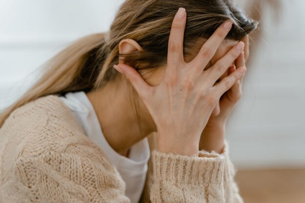 Woman covering her face while greening out.