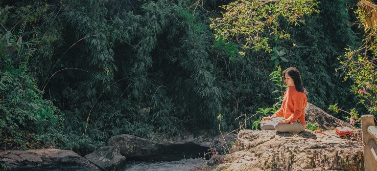 A woman sitting in a yoga pose outdoors