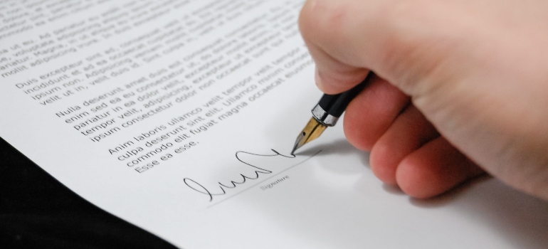 A person signing a document about decriminalization vs legalization of drugs