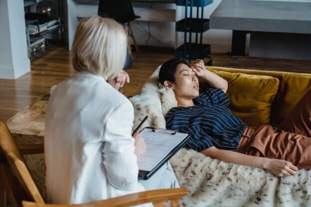 A woman laying on the couch in a therapy session