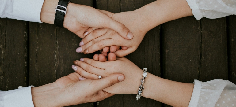 Two women are holding hands and supporting each other.