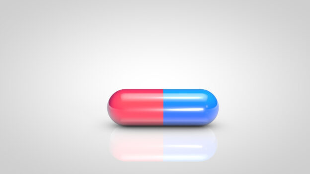 A single pill staying still on a white table.