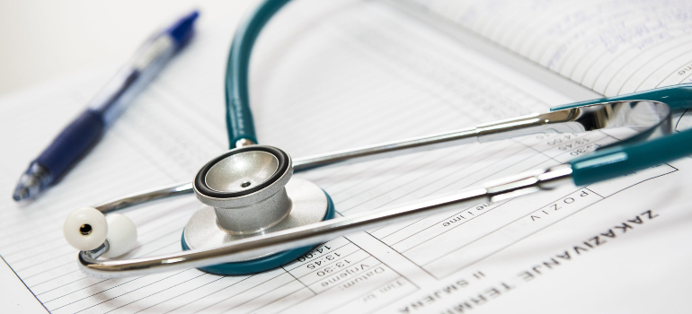 A stethoscope and a pen resting on a medical chart, elements commonly associated with monitoring the opioid withdrawal timeline.