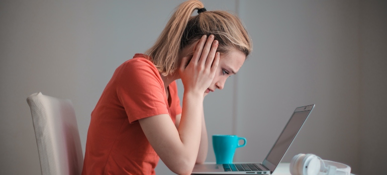 Woman sitting with a lap-top on a desk.
