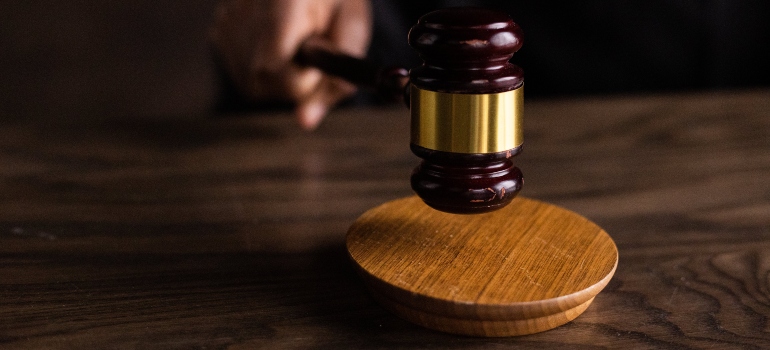 Brown wooden gavel on brown wooden table.