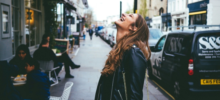 A woman smiling and looking at the skies.