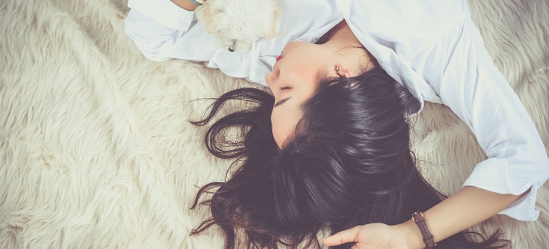 A girl sleeping with her dog in her arms.