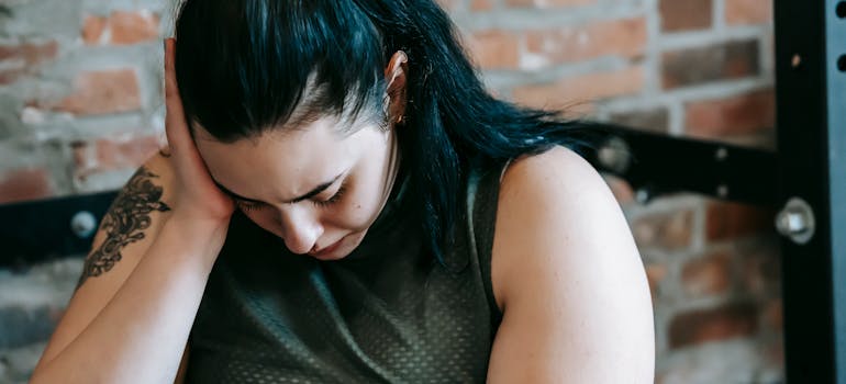 woman holding her head in distress because of the link between marijuana and schizophrenia.