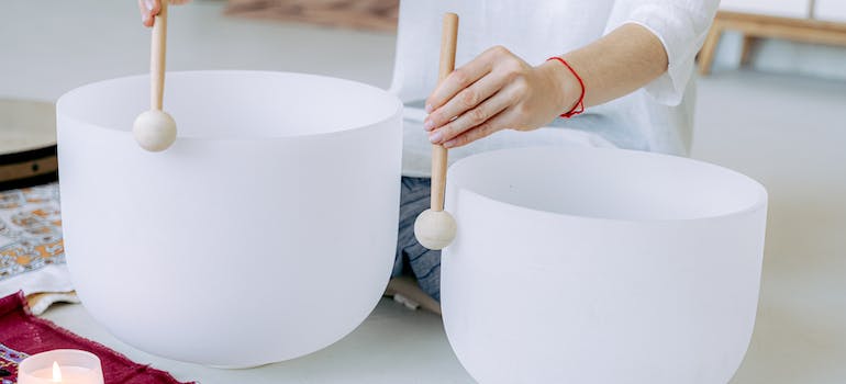 A person using two instruments for sound bath theraoy