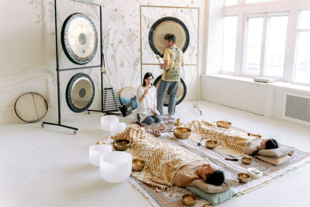 Two people lying on the floor and two therapists performing sound bath therapy as a complementary approach to addiction treatment.
