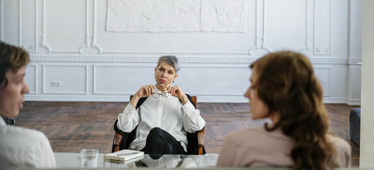 A man and a woman talking to a therapist about PTSD and substance use disorder