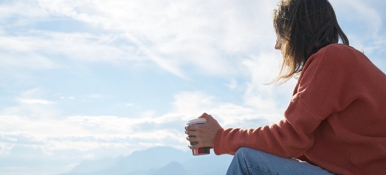 A person is sitting outdoors and thinking of the neuroscience behind cravings.