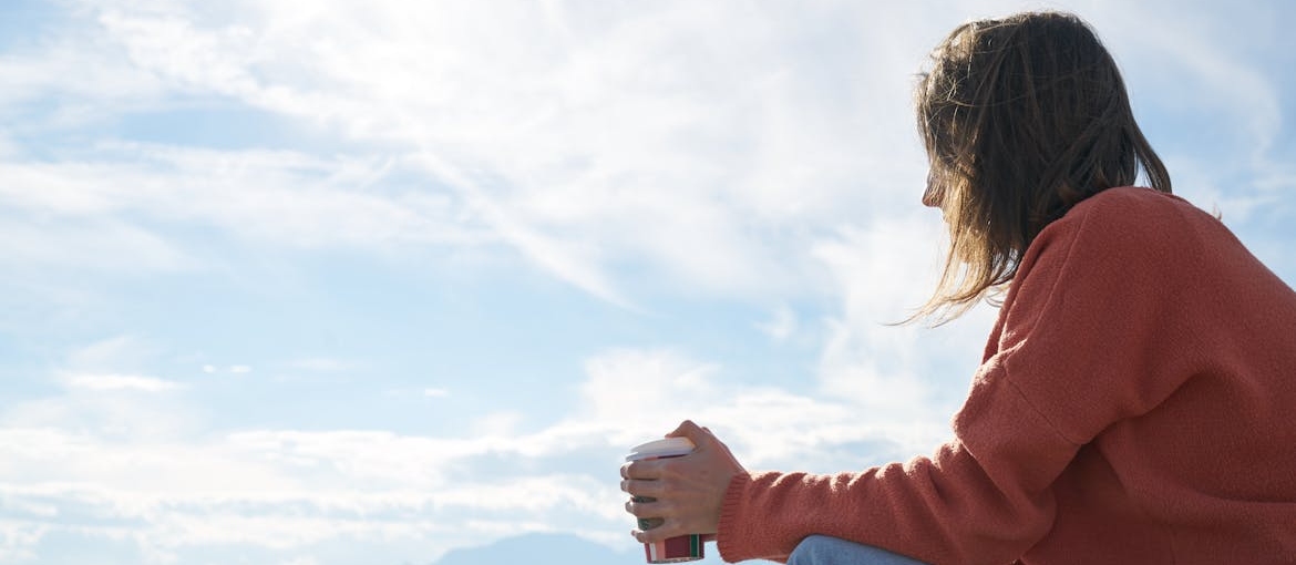 A person is sitting outdoors and thinking of the neuroscience behind cravings.