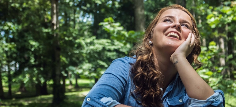 A woman is looking up, smiling.