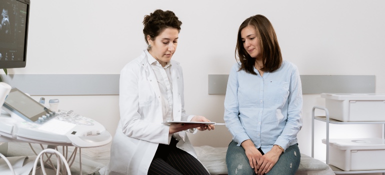 A pregnant woman talking to a doctor about the effects of drug abuse on fertility