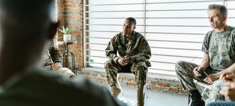 Men in military uniforms talking in group therapy
