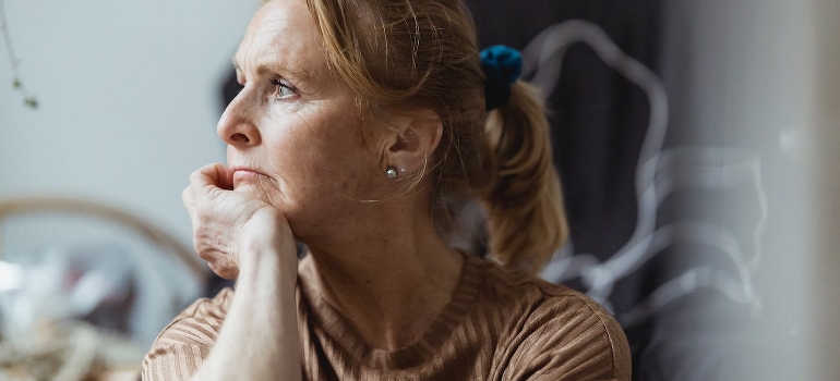 A senior woman is thinking about neuroplasticity in addiction and recovery.