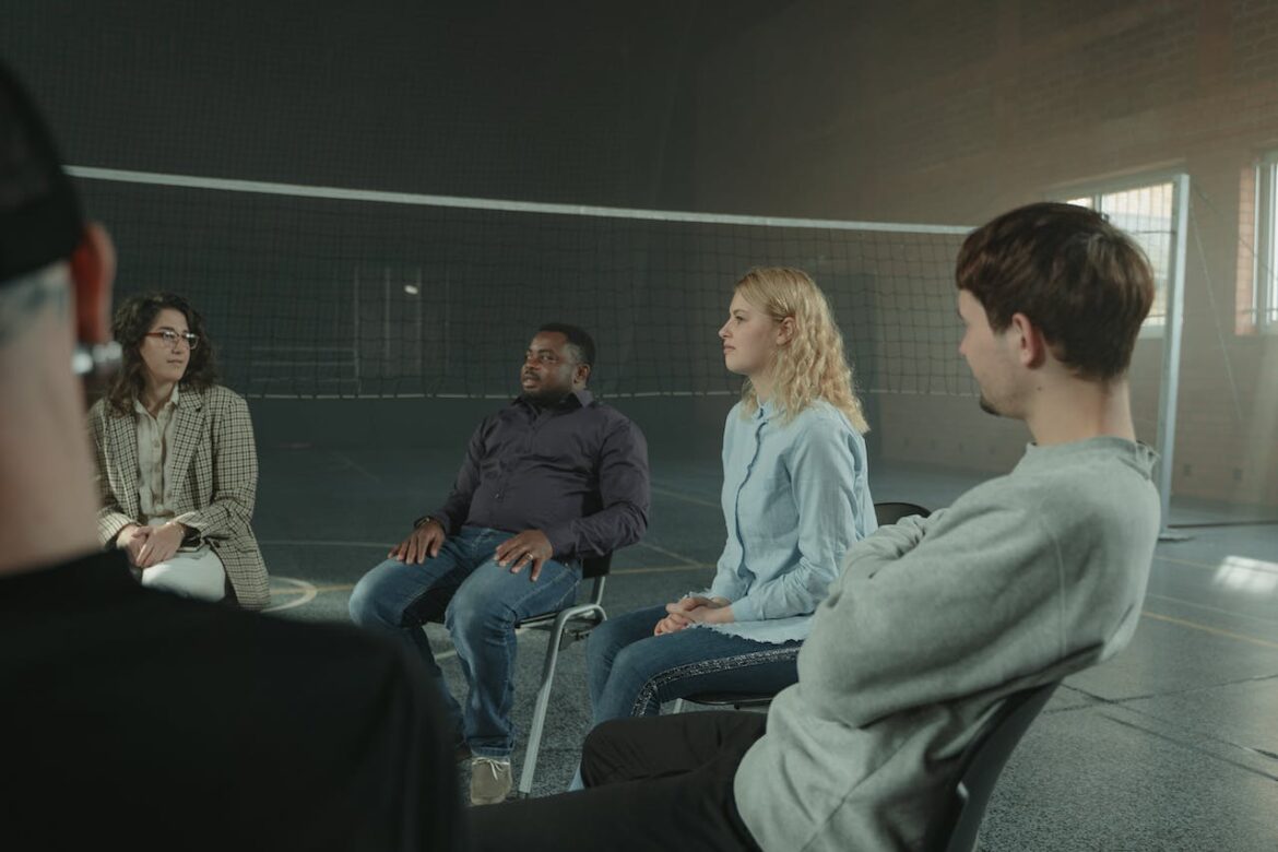 People in group therapy talking about principles of the 12-step program.