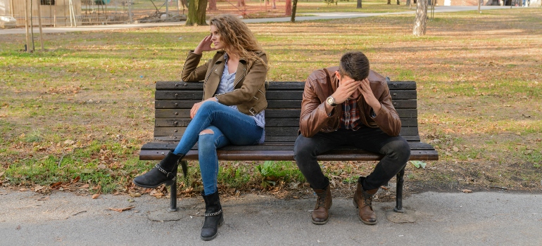 A nervous man and a woman sitting on a bench