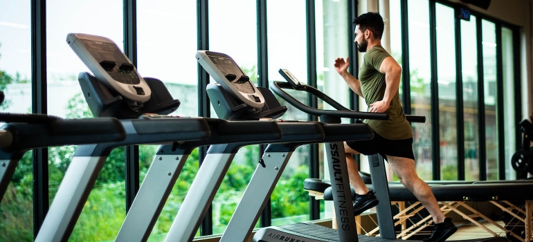 A man is working out in a gym while thinking of neuroplasticity in addiction and recovery.