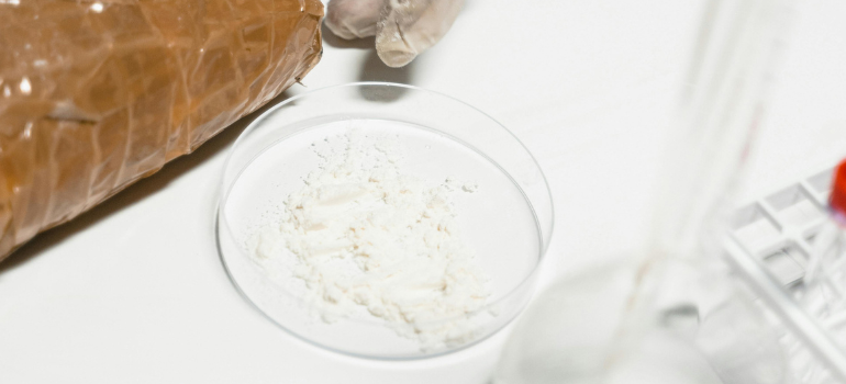 some cocaine, one of the hardest drugs to quit, in a clear container in a laboratory