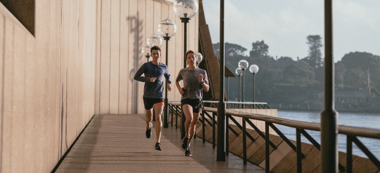 Two people jogging near a body of water