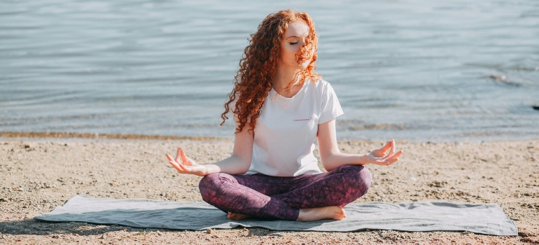 A woman meditating on a beach