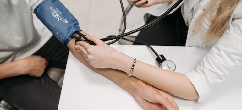 female doctor checking a man's blood pressure.