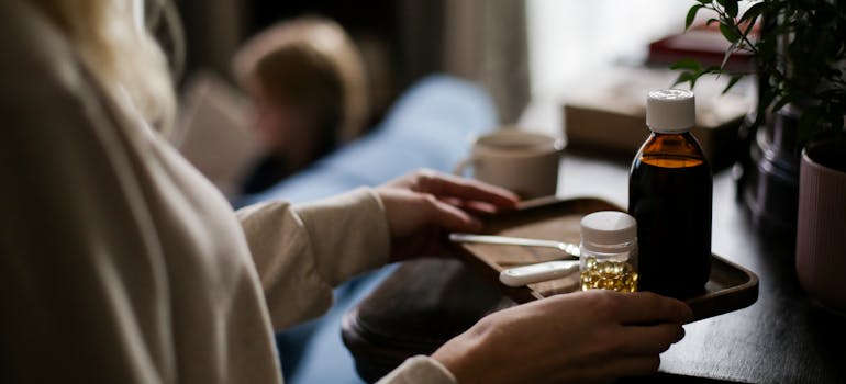 woman carrying a cough syrup on a tray.