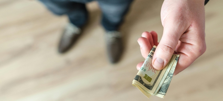 A man holding a bank note for handling money in addiction recovery