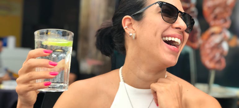 Woman drinking water to prevent the dangers of social drinking.