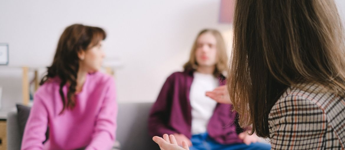 Adults talking together during a supportive behavioral health counseling session.